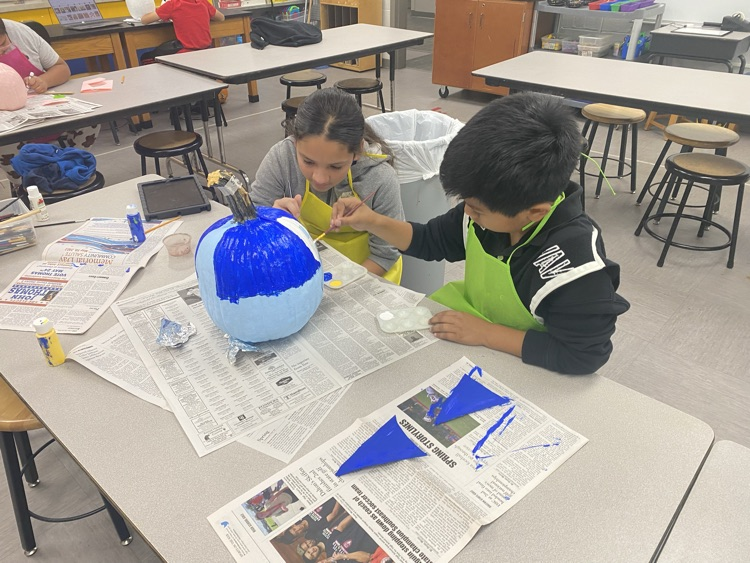 students decorate pumpkins 