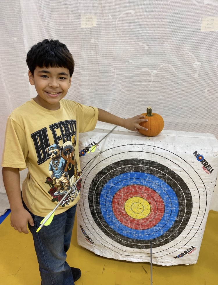 A students showing the spot the arrow made on the pumpkin 