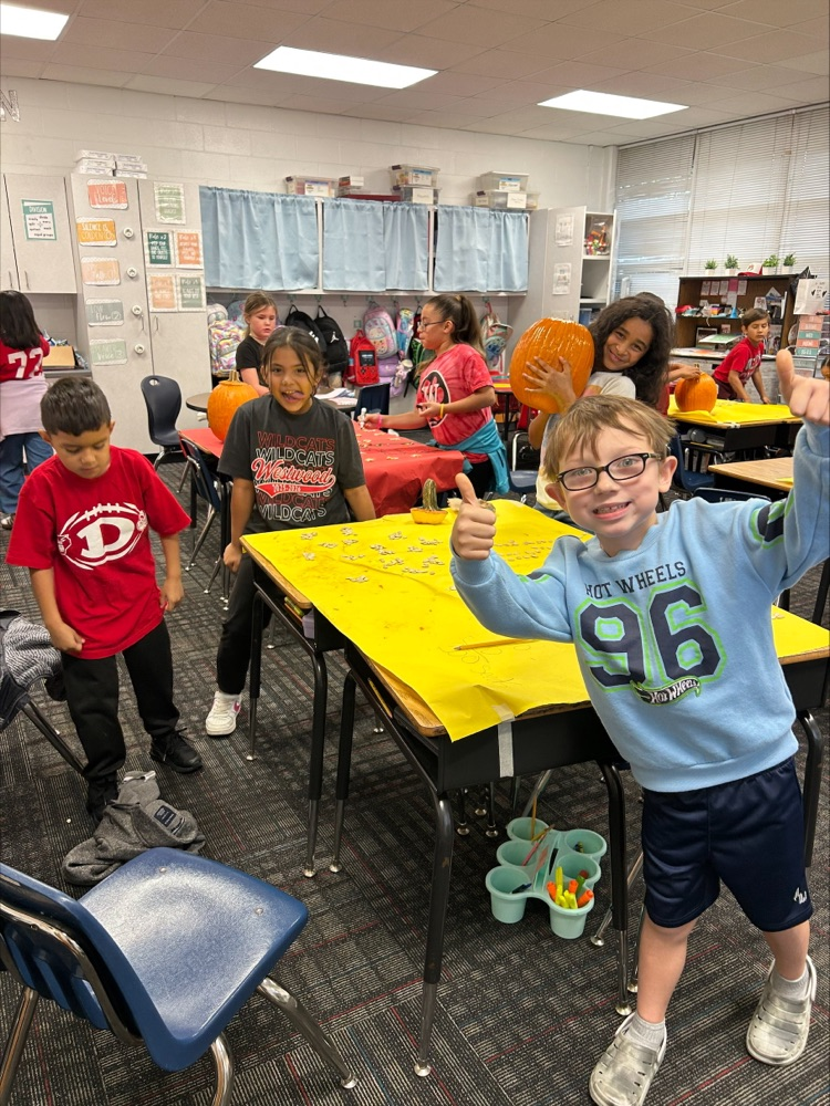 A student giving a thumbs up on his work 