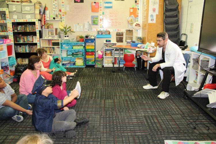 A dentist showing the students how to brush your teeth
