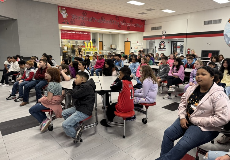 Fourt grade students in the cafeteria listening to the presentation 
