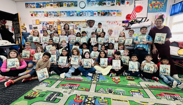 A group picture with Mr. Soriano and students holding their books 