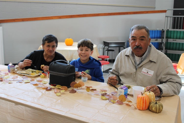 A student eating with his grandparents