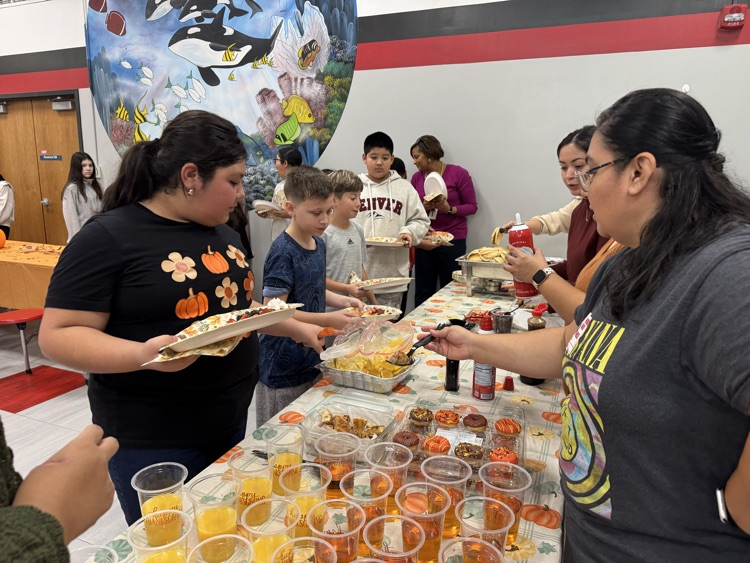 Parents serving food to students 