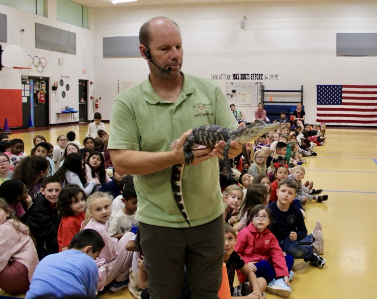 A picture of the presenter holding the alligator 