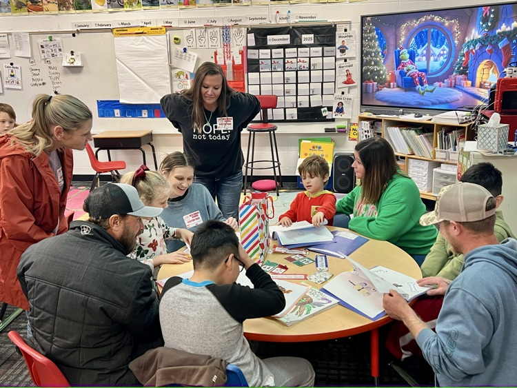 Students sharing their writing papers with teachers and parents