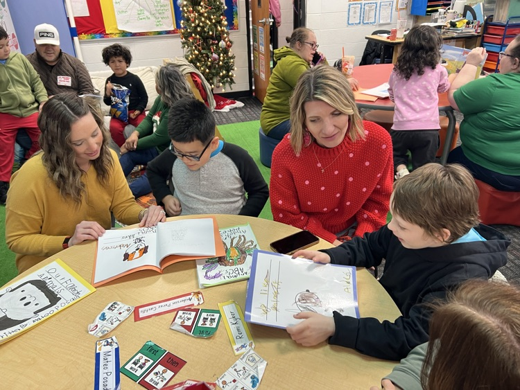 Mrs. Smith and Mrs. Ridley reading the writing papers with students