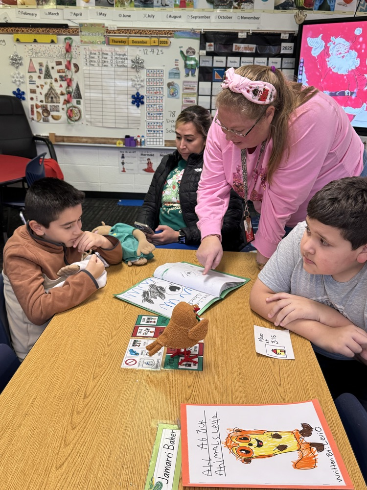 Mrs. Cody reading a writing paper with a student