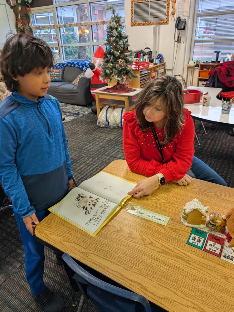 A teacher reading a writing paper with a student