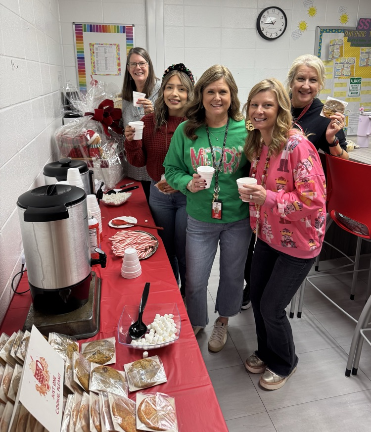 Staff holding their cocoa and cookies