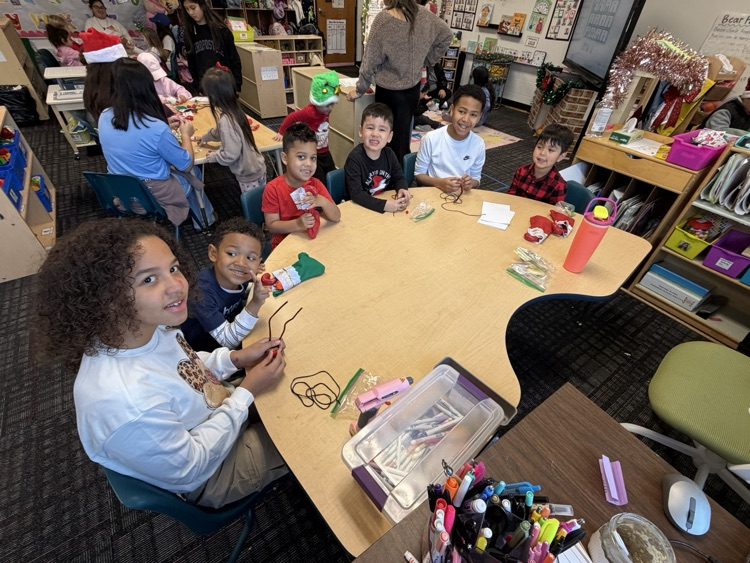 A small group of 5th graders with their buddies working on their necklaces