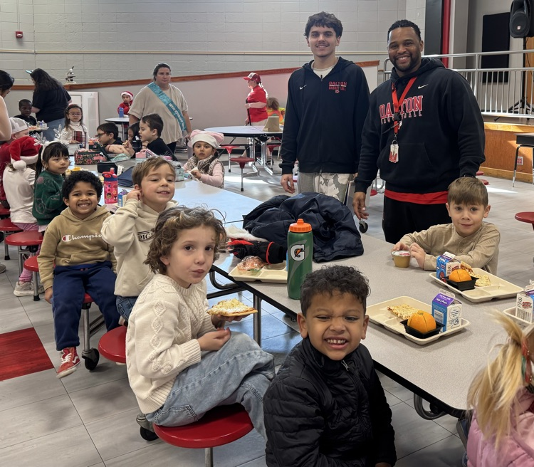 Basketball player and a coach with students during lunch time