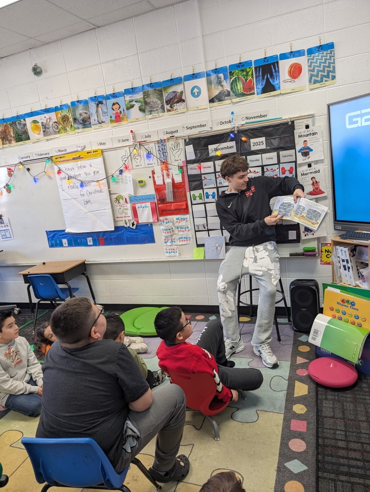 A basketball player reading to a class
