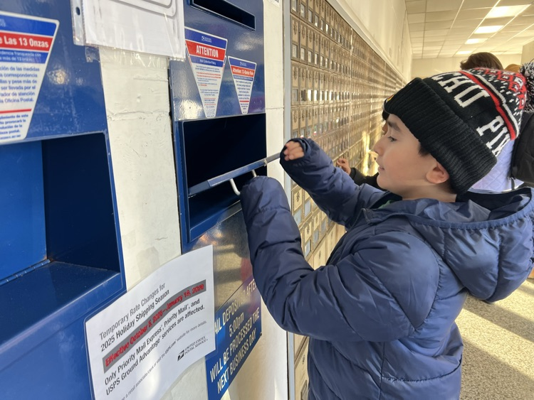 A student dropping his letter at the mail box. 