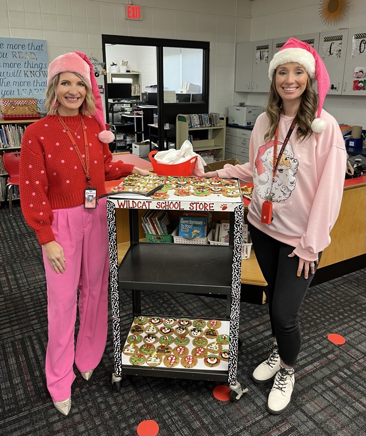 Principal and AP giving Christmas cookies 