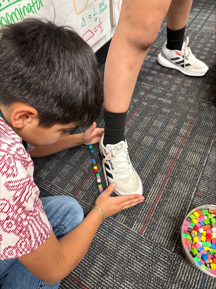 A student measuring a show with small blocks