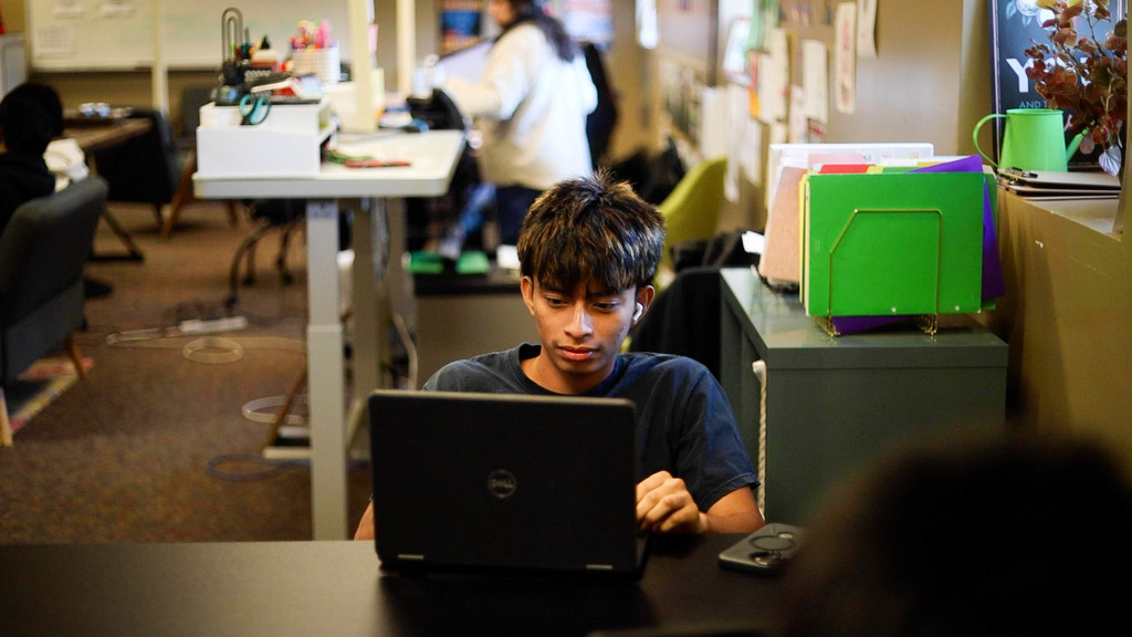 A Cyber Academy student works independently on a laptop in a flexible learning space.