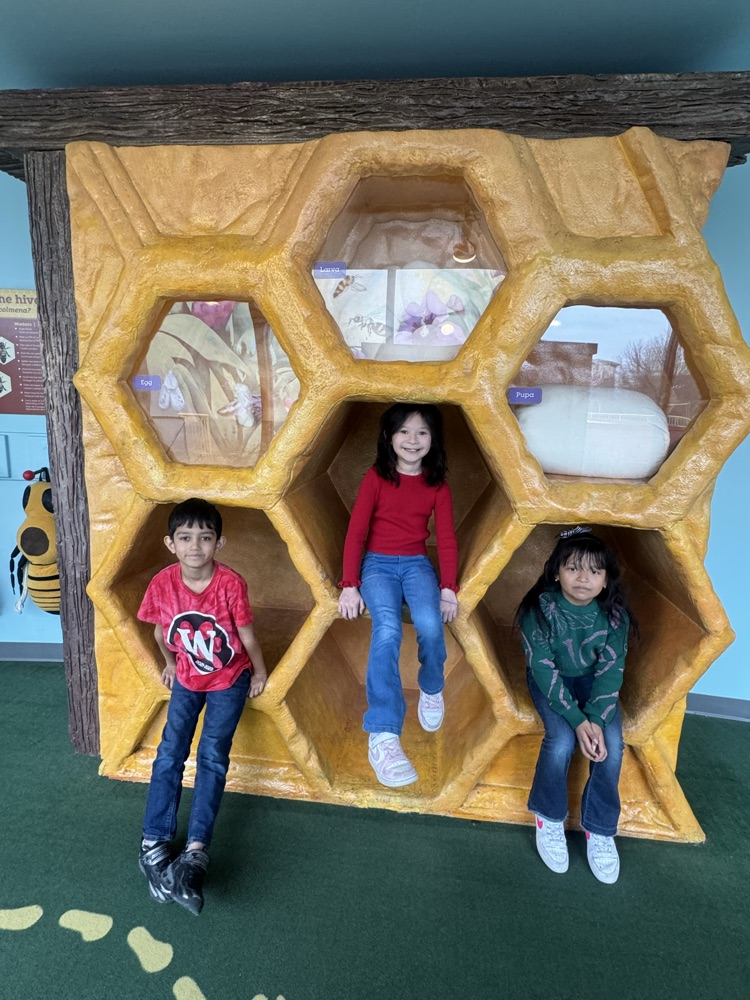 Students taking a picture in a giant beehive