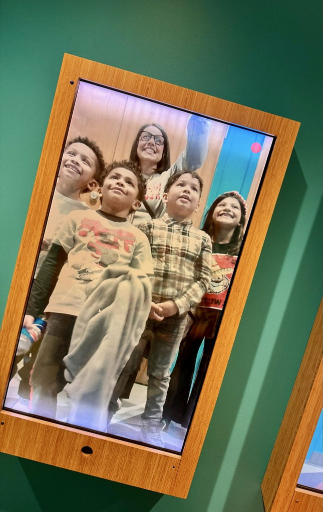 A picture of student in front of a big mirror screen 
