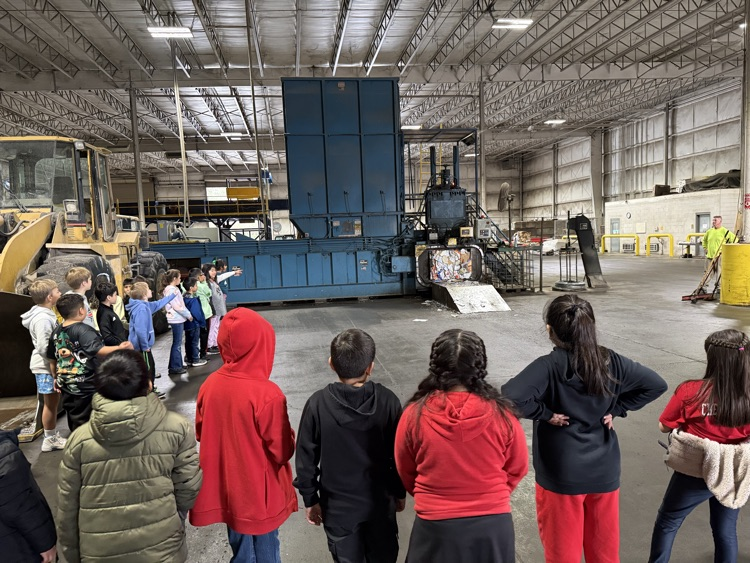 Students observing how to machines processes the trash 