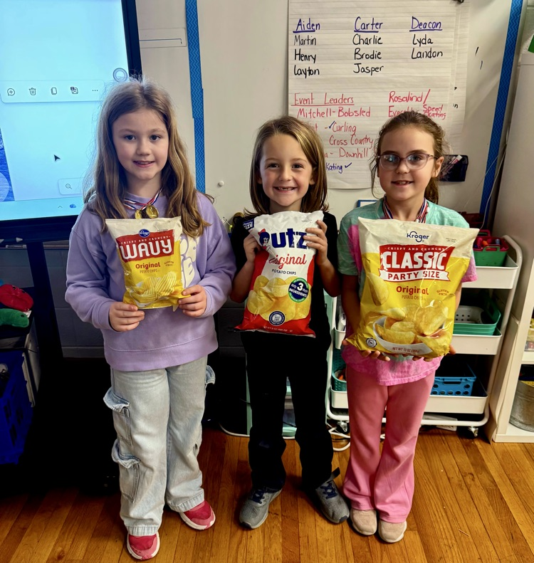 Second graders holding potato chips bags 