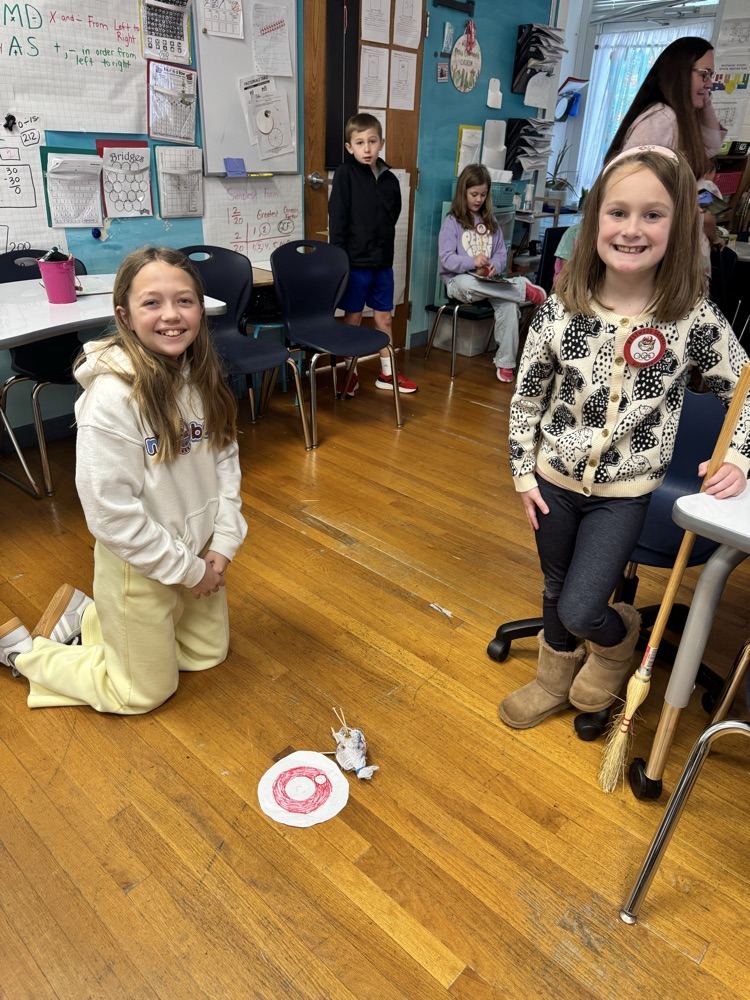 A second and a fifth grader practicing curling with a potato 