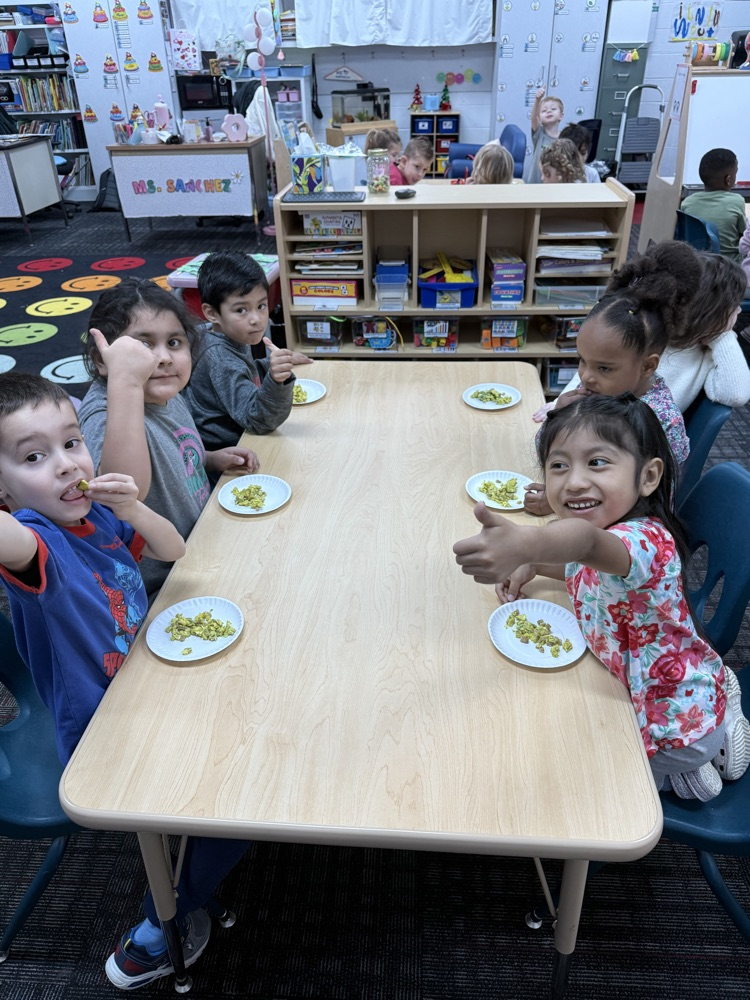 Students giving thumbs up to green eggs and ham