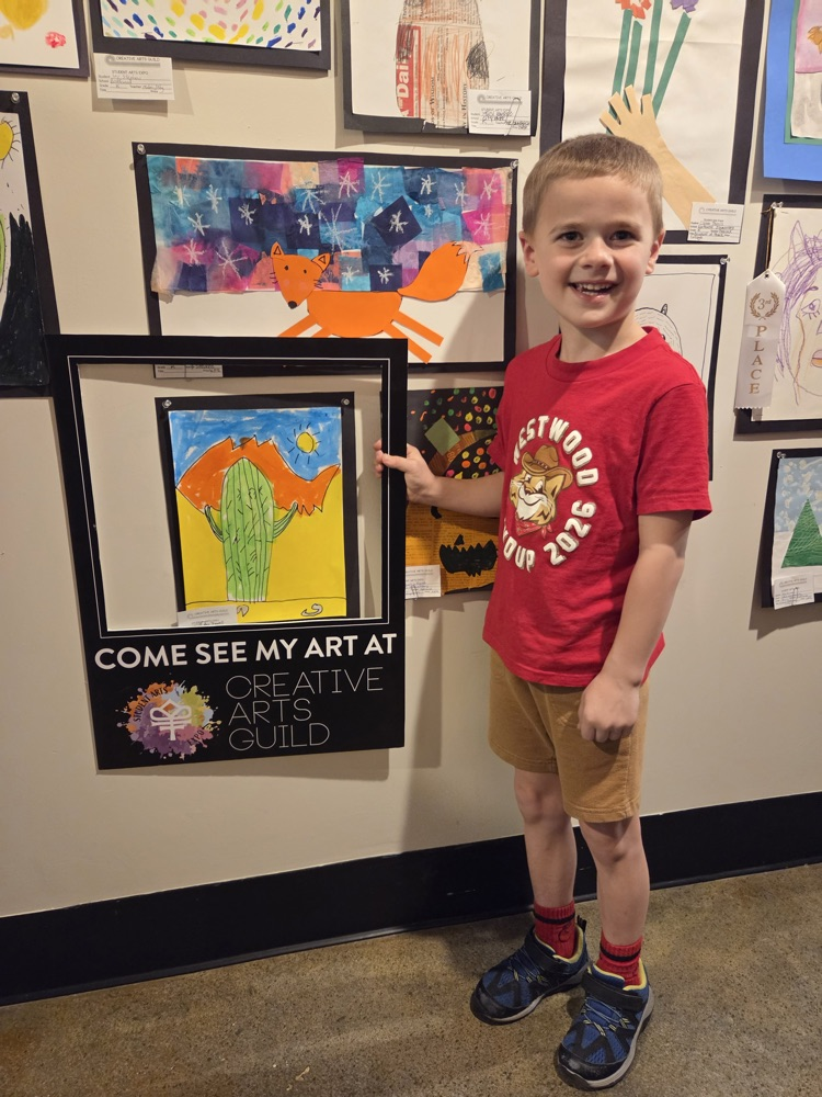 Student taking a picture with his artwork 