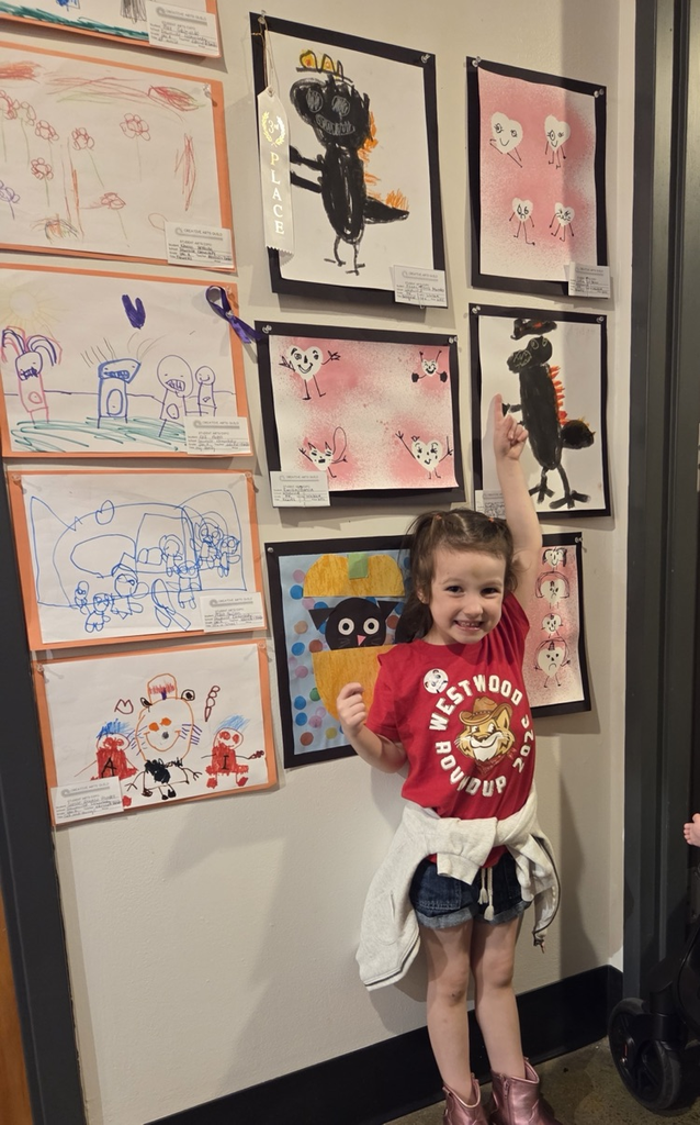 Student pointing at her artwork 