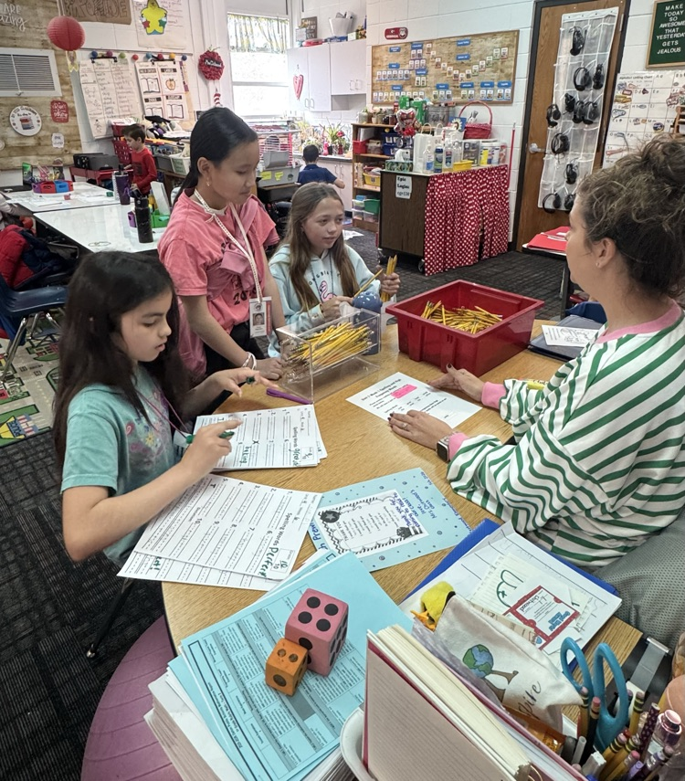 Students helping a teacher in the classroom 