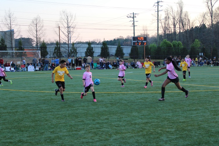 A soccer player kicking the soccer ball 