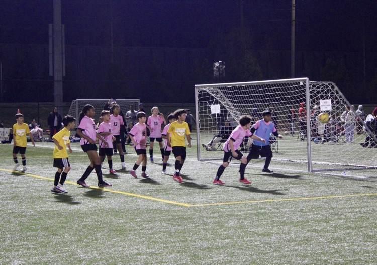 Soccer players defending their net  