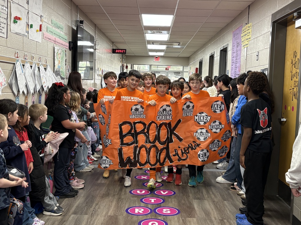 students carrying a soccer tournament banner