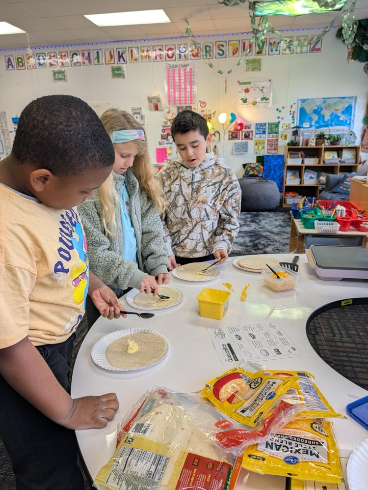 Students spreading butter on a tortilla