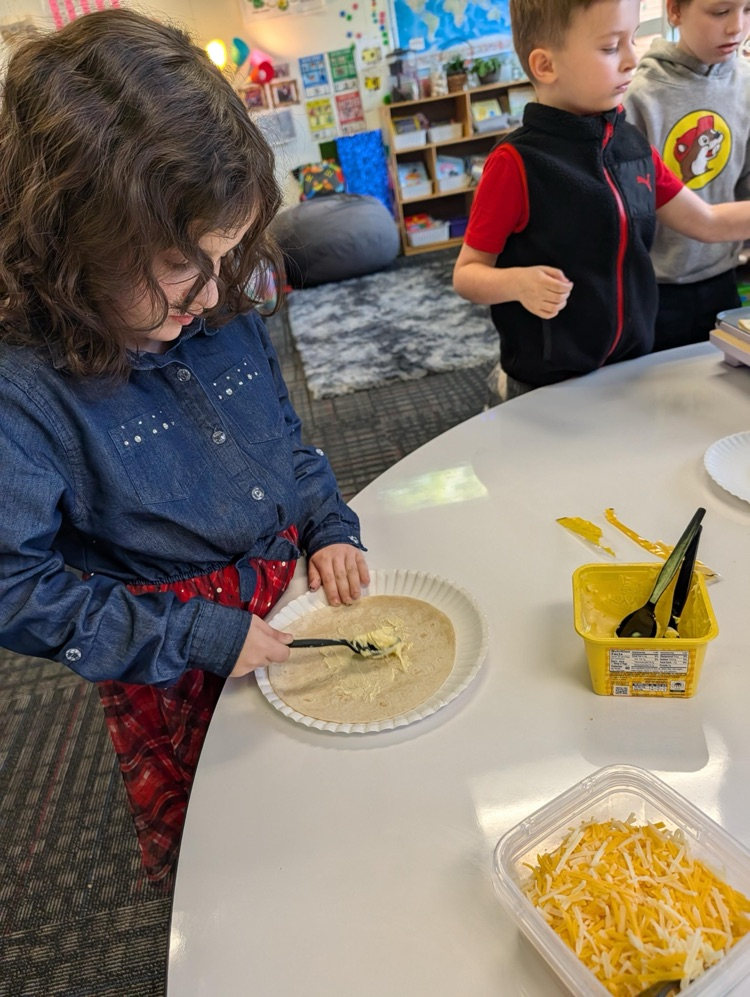 Student spreading butter on her tortilla
