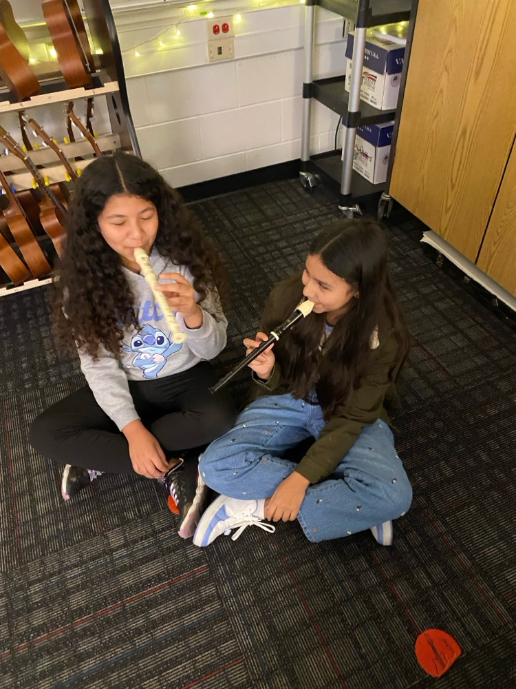 Two students playing the recorder