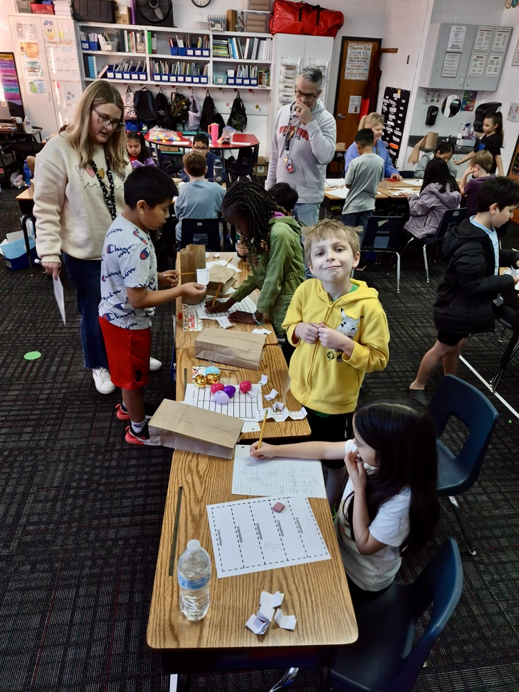 Students opening their eggs to find their math problems 