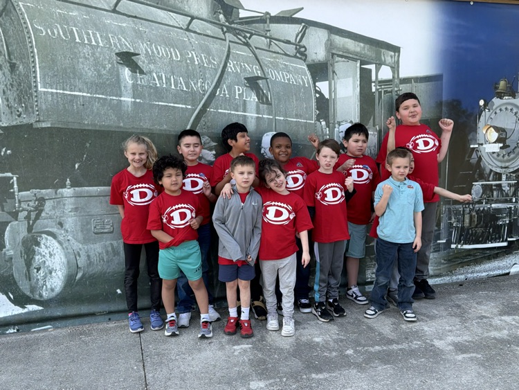 Students taking a picture in front of a train mural 