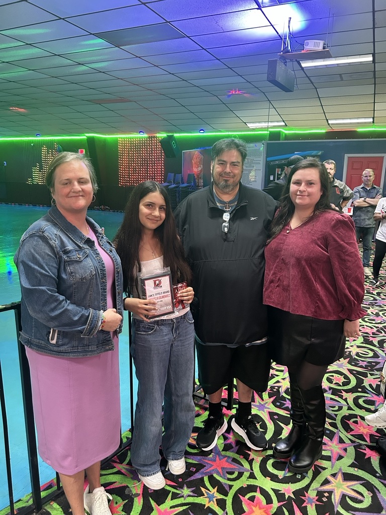Four people stand holding an award.
