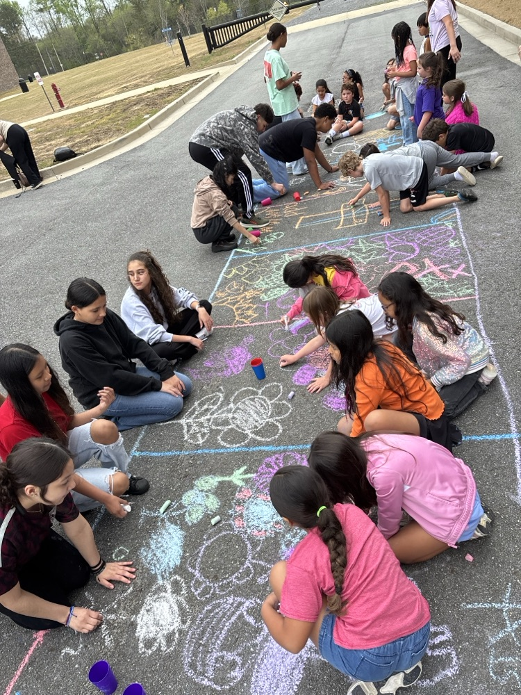Students sketching the alfombra’s designs on the ground  