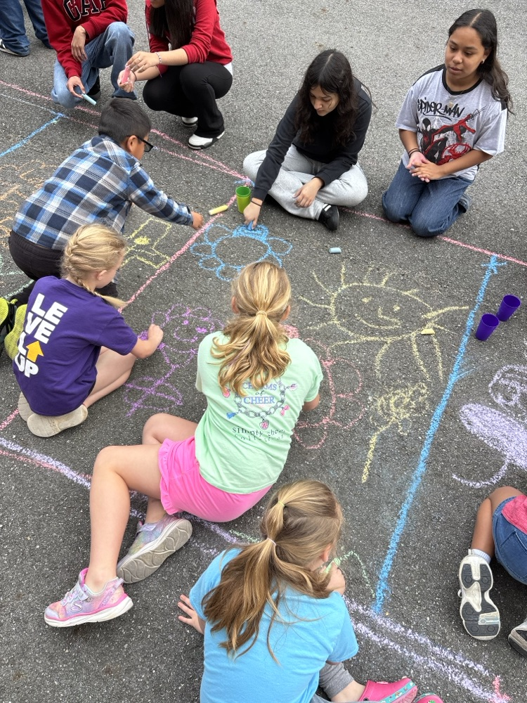 Students sketching the alfombra’s design on the ground 