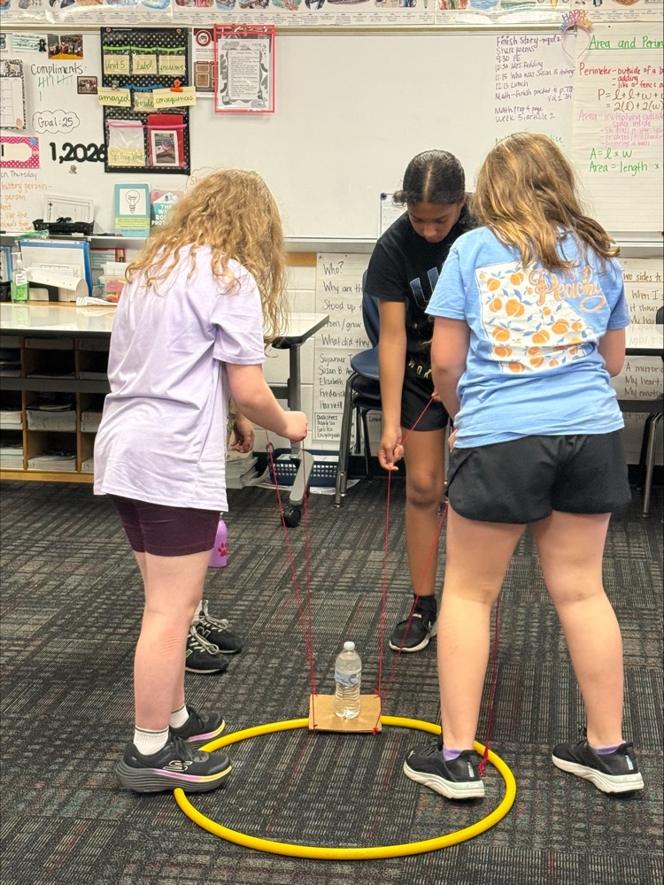 Three students following directions and working together to achieve a task