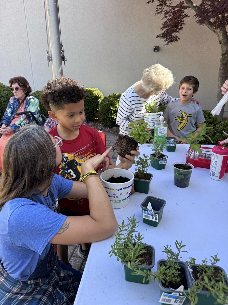 Teacher showing the roots of a plant to a student 