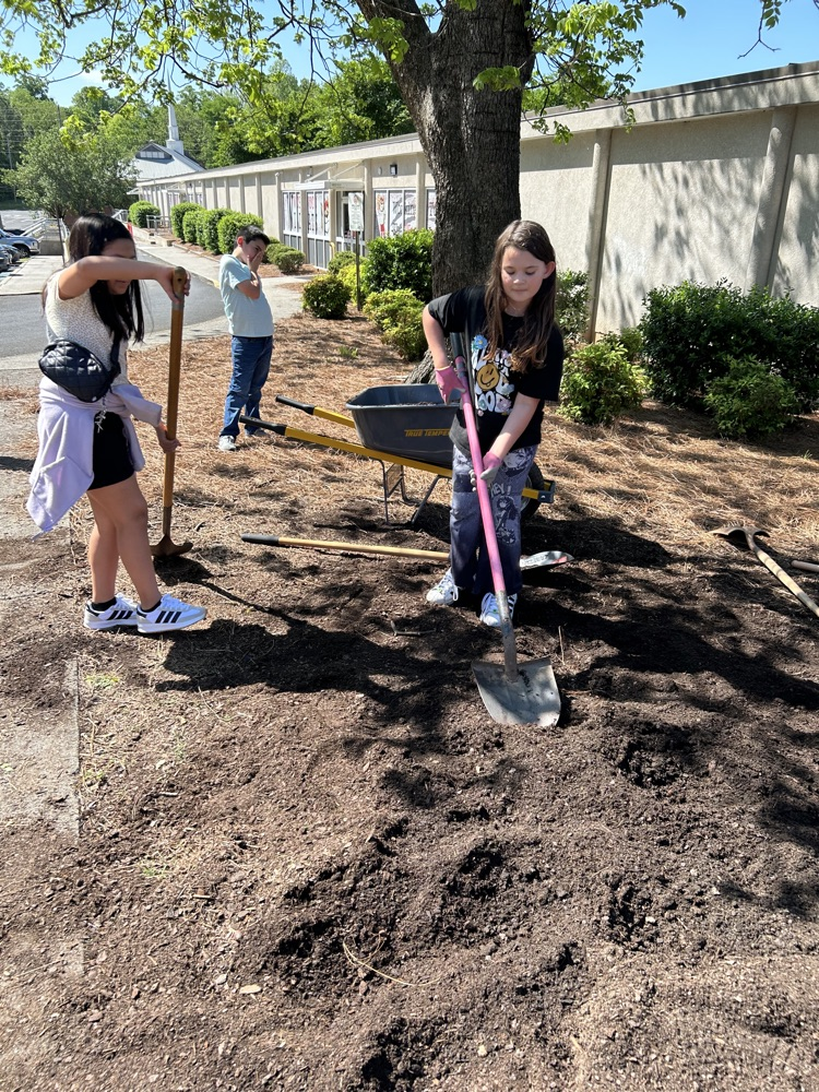 Students shoveling dirt for the flower beds 