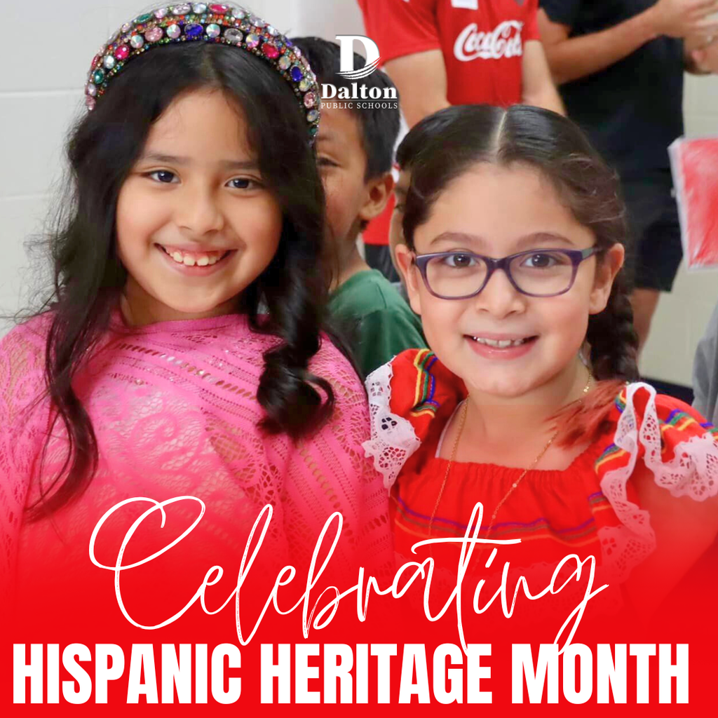 Two smiling young girls stand together at school, one wearing a pink top and jeweled headband and the other wearing glasses and a colorful traditional-style dress. Overlaid text reads “Celebrating Hispanic Heritage Month,” with the Dalton Public Schools logo above.