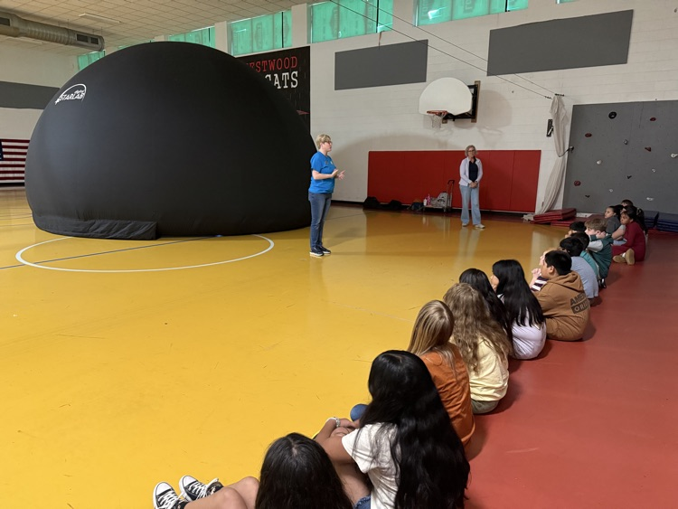 Students in the gym listening to the instructor about the Star Lab