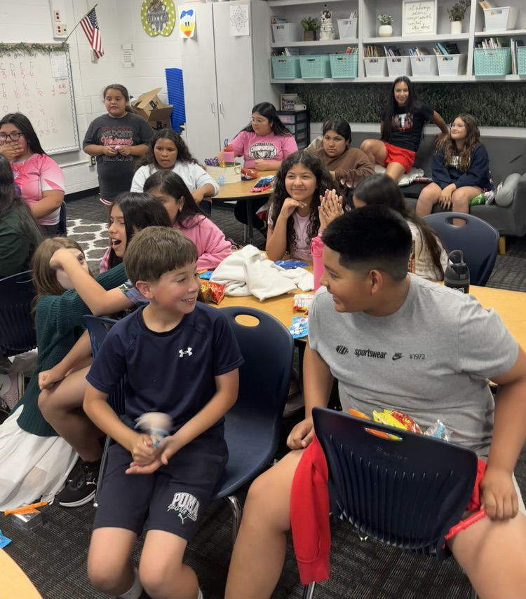 A group of students sitting on their desk in their class waiting for the teacher to draw a name  
