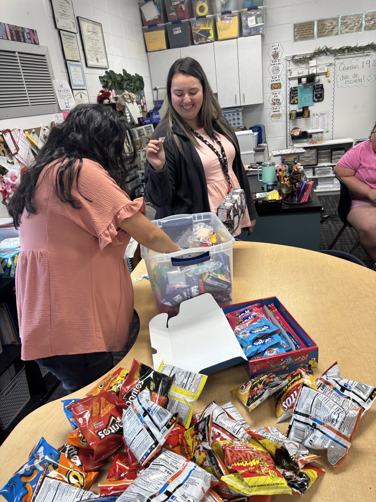 Mrs. Witten drawing a name from the bucket filled with all the raffle tickets. Mrs Gomez holding a ticket 