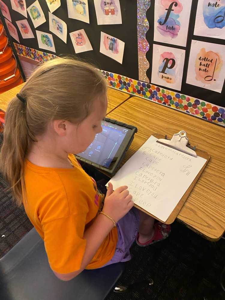 A student siting on her desk holding her iPad 