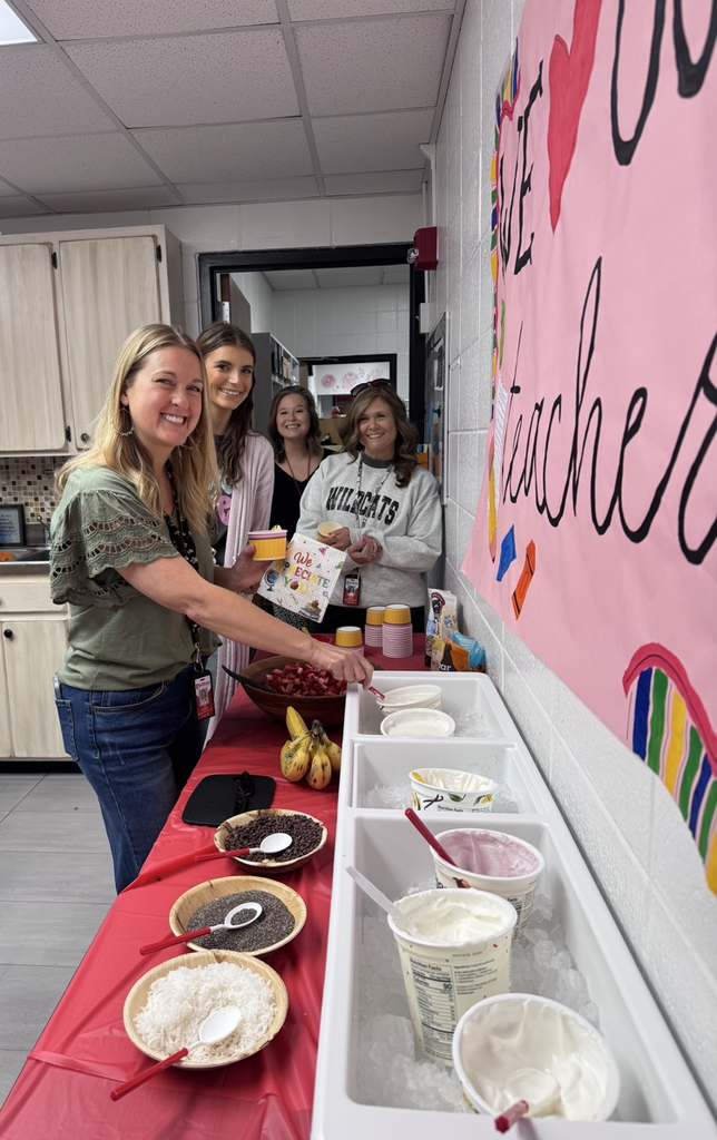 Four teachers in line to get their yogurt cups from the yogurt bar provided by PTO